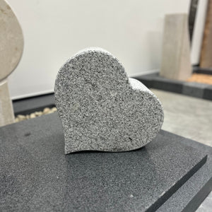 Ein Herz angefertigt aus Granit liegt auf einer Diorit Platte